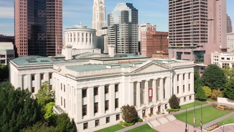 COLUMBUS, OHIO - SEPTEMBER 29, 2020: Aerial revealing shot of the Ohio State House and Columbus skyline with pull back and up camera motion.