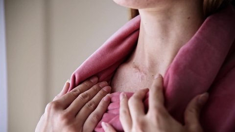 Woman hiding a surgery scar on neck with a sweatter collar.