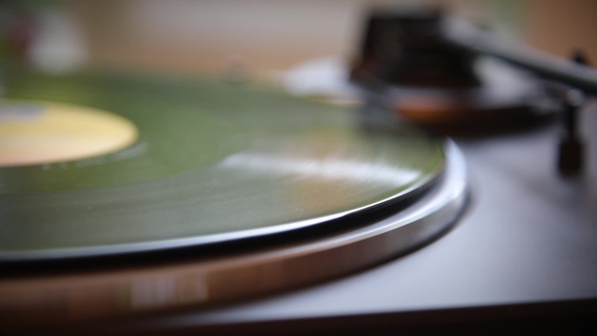 Hand turns on a vintage vinyl record. The needle rises from a vintage vinyl record. The vinyl record is spinning. The needle plays on a vintage vinyl record. Old turntable. Royalty-Free Stock Footage #1061069224
