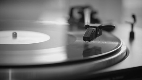Black and White. The needle goes down on a vintage vinyl record. The vinyl record is spinning. The needle plays on a vintage vinyl record. Old turntable.