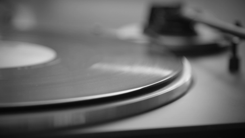 Black and White. Hand turns on a vintage vinyl record. The needle rises from a vintage vinyl record. The vinyl record is spinning. The needle plays on a vintage vinyl record. Old turntable. Royalty-Free Stock Footage #1061069263