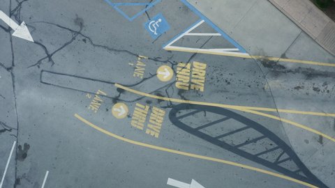 Rotating overhead shot of cars pulling in to drive thru lane at a fast food restaurant drone aerial