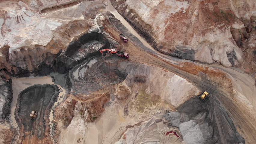 Iron ore quarry open pit mining. Aerial view of excavators and machinery are loading ore into dump truck in quarry. Large industrial quarry Royalty-Free Stock Footage #1061070946