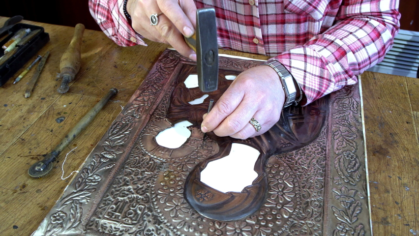 Designing copper utensils, the age old art of crafting copper wares. Master craftsman making copper product. Copper master, hands detail of craftsman at work