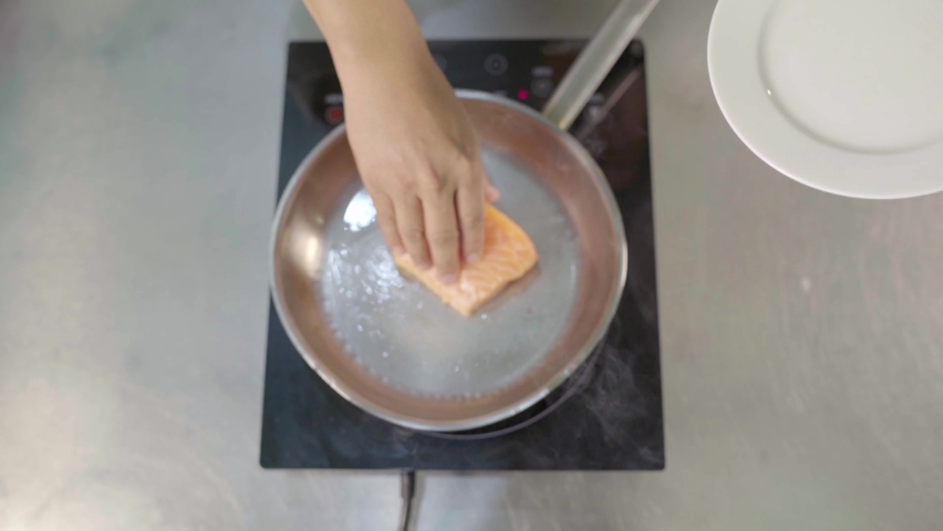 Hot pan with oil, presentation of a piece of salmon steak.