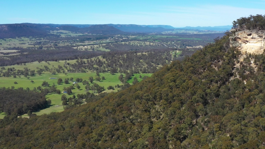 Aerial footage of Hassans Wall rock formation and Hartley Valley near Lithgow in The Central Tablelands in regional New South Wales in Australia