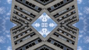 Time lapse video of empty old disused concrete building with clouds moving in the sky, El Poblenou, Barcelona, Spain made into abstract mirrored pattern