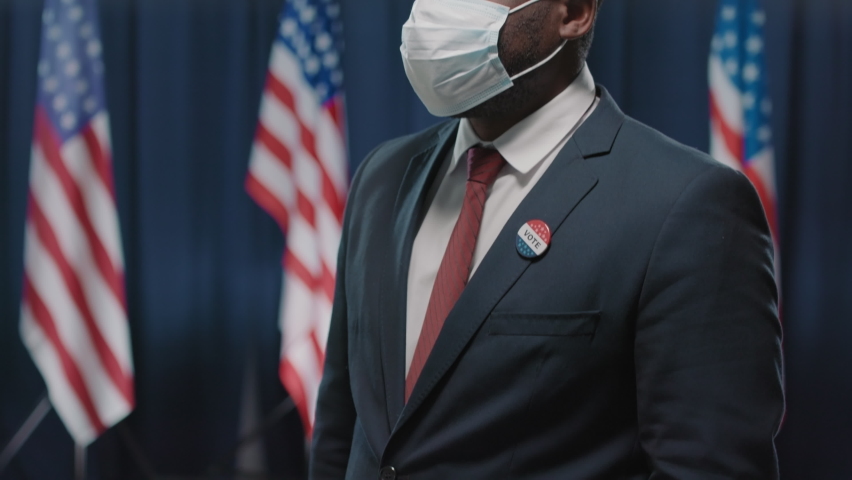 Portrait footage of African American candidate for United States presidency demonstrating self awareness wearing protective mask