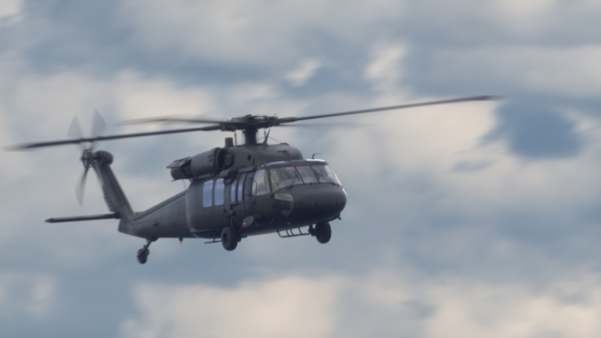 The helicopter flies high in the sky. Production quality footage in 4k.