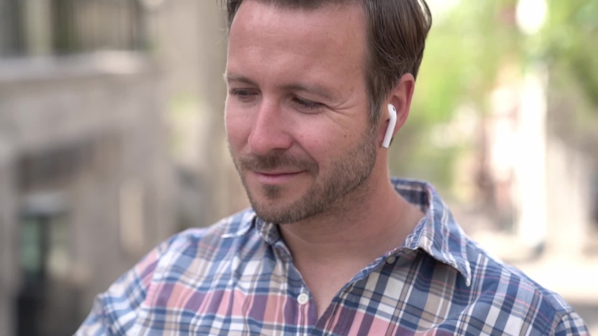 Portrait of an handsome man on the urban background listening music | Shutterstock HD Video #1061088400