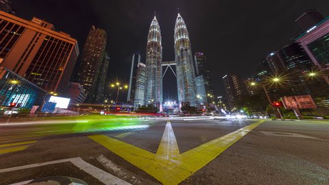 KUALA LUMPUR - SEPTEMBER 26: (Timelapse view) Traffic and pedestrians near The Petronas Towers at night of September 26, 2019 in Kuala Lumpur, Malaysia. Pan up motion Time lapse.