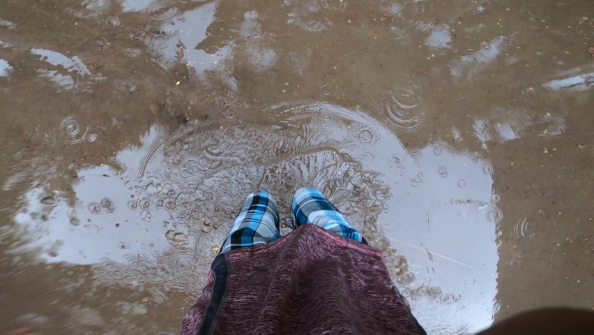 Point Of View Of A Man Jumping On A Rain Paddle On A Concrete Floor. - POV Shot