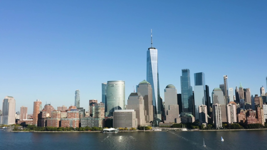 a drone flyby in the afternoon of lower manhattan, ny. the freedom tower prominently shows its height against a clear bright blue sky. Royalty-Free Stock Footage #1061093980