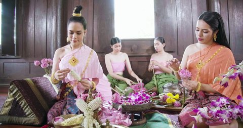 A beautiful asian female dress on Ayutthaya cultural fashion clothes sitting and flower decuration training traditional Thailand tomyam in the vintage old style ancient house