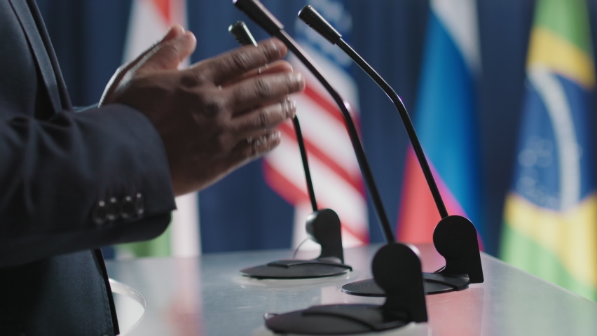 Side view close-up footage of hands belonging to African male politician speaking about important global issues during international meeting Royalty-Free Stock Footage #1061104603