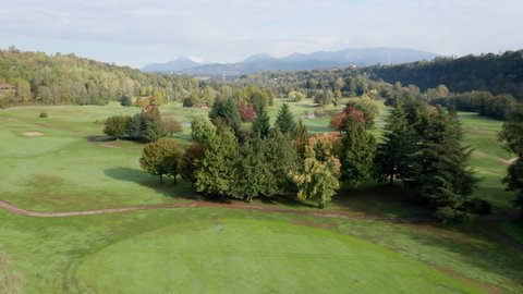 Aerial view of golf course with a rich green turf, putting green, sand bunker and water hazards.