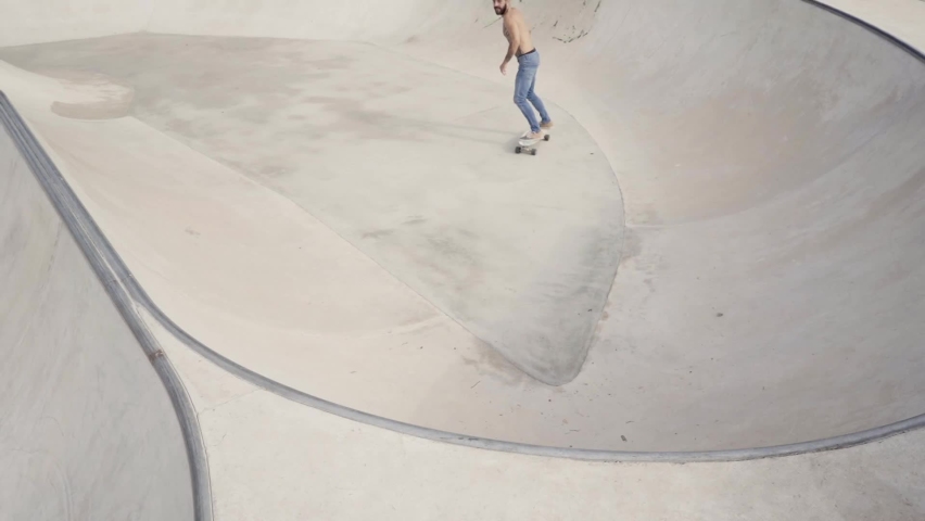 Man rides a skateboard in the bowl of a skate park. Gray background. | Shutterstock HD Video #1061108326