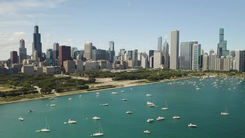 Drone Descends to Reveal Yachts and Sailboats in Harbor. Chicago Skyline in Background