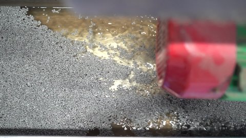 cinematic shot of grey recycled plastic pellets being rinsed in a recycling plant