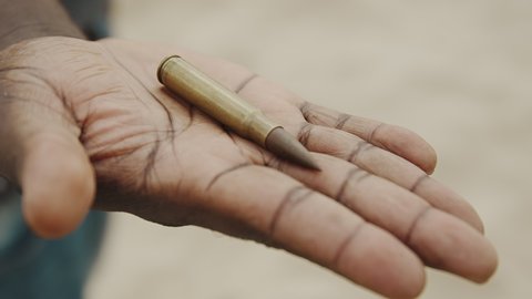 Armed African Man Showing One Piece Of Bullet On His Palm - Closeup Shot