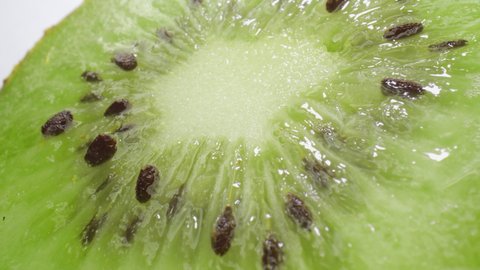 Squeezing a fresh and juicy kiwifruit. Extreme close up.