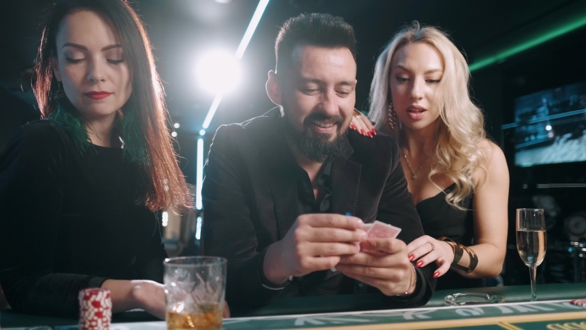 Two young women and bearded man are winning and rejoice in victory at the casino Royalty-Free Stock Footage #1061112919