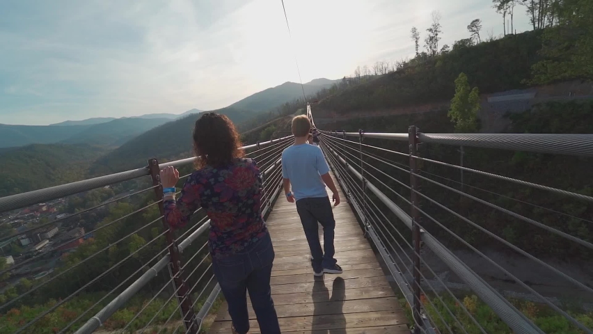 Family on vacation in Gatlinburg Tennessee on Swinging bridge at sunset . High quality FullHD footage. Longest swinging bridge on the east coast in the Smokey Mountains.