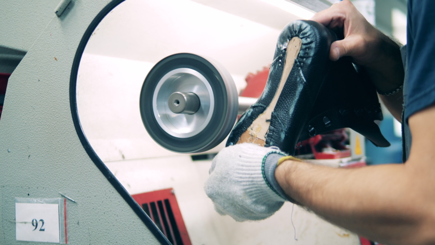 Shoemaker grinding a shoe at a shoe manufacturing plant