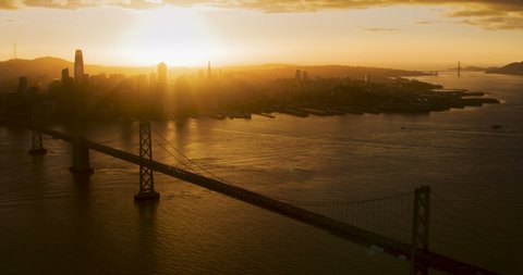 Aerial view of the Oakland bay bridge during sunset. Backlight. San Francisco, California. United States. City skyline in the background. Shot on Red weapon 8K.