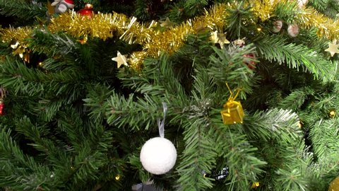 Camera panning through Christmas tree showing decorations and ornaments and revealing a beautiful Golden Star tree at the top