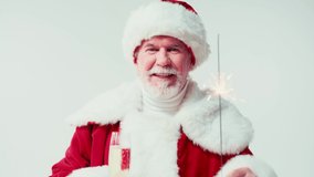 happy santa claus holding sparkler and glass of champagne isolated on white