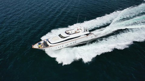 Aerial drone tracking video of luxury yacht cruising in deep blue Aegean sea, Greece