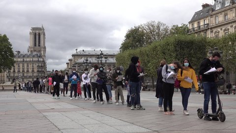 PARIS, FRANCE – SEPTEMBER 2020: Long queues for Covid-19 coronavirus testing facility, with famous Notre Dame cathedral in the background, in downtown Paris. France struggles to control a second wave 
