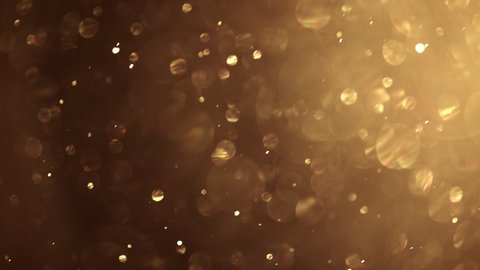 Gold dust particles fly in the air. Glimmering glowing gold bokeh background. : vidéo de stock