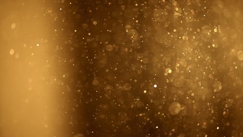 Shining golden particles abstract background. Blurred bokeh background of gold dust particles slowly floating in the air. Magical fairy background