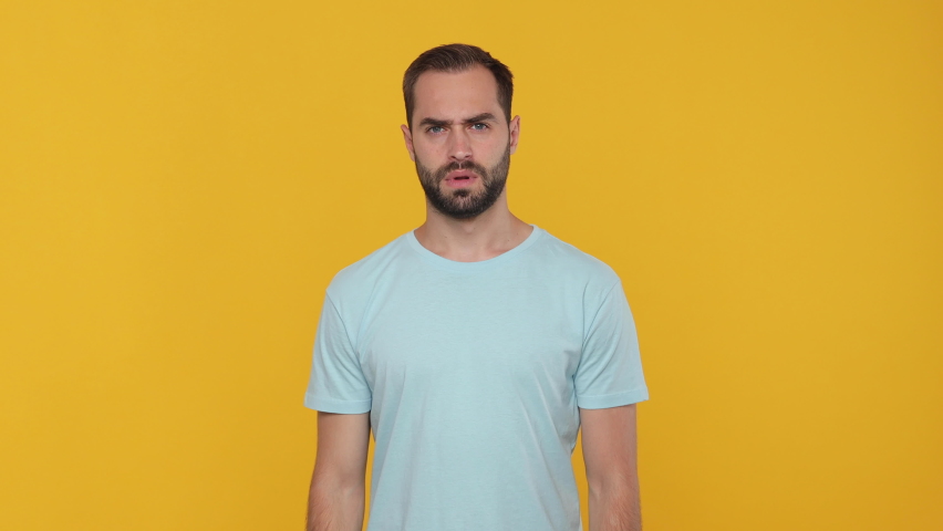 Young angry sad man 20s years old in basic casual blue t-shirt isolated on yellow background studio. People emotions lifestyle concept. Looking at camera showing stop gesture crossed folded hands palm Royalty-Free Stock Footage #1061129944