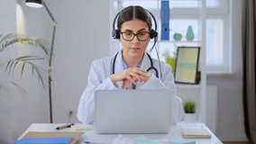 Young Female Doctor Wears White Coat, Video Calling Distant Patient on Laptop. Doctor Talking to Client in Home Office Visit Computer app. Telemedicine, Remote Healthcare Services Concept Video Call