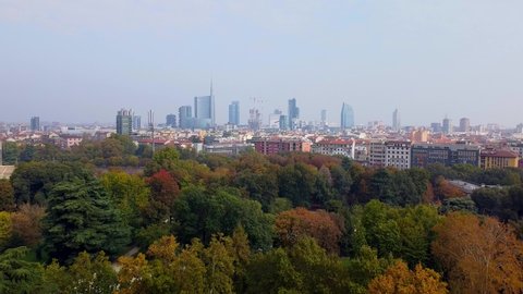 Aerial view of autumn trees in sempione park next to castello sforzesco castle. City and roofs of buildings. View of modern skyscrapers. Ecology. Green Planet. Milan. Italy, 22/10/2020: