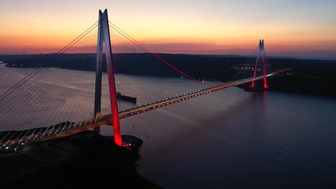 Istanbul Bosphorus at sunset. Yavuz Sultan Selim Bridge with the lights and red reflections in Sea. Bridge crosses the Bosphorus Strait between Garipçe village on the European side and Poyraz 