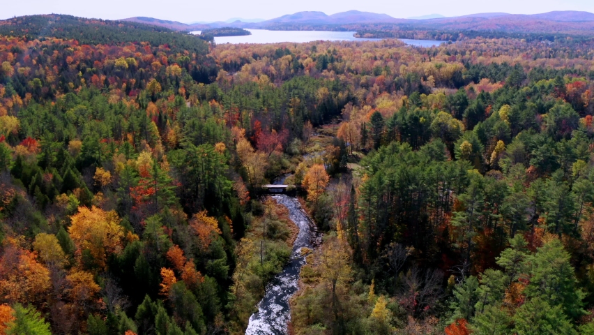 Aerial flythrough of Winding River Through Autumn Trees with Fall Colors in Adirondacks, New York, New England, USA