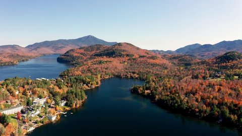 Aerial flythrough over Lake Placid and Mountains during Autumn Fall Colors in Adirondacks, New York, New England, USA