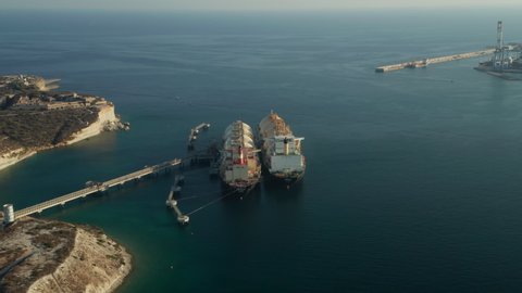 Huge LNG Gas Tankers Storing Gas in Huge containers in Ocean before mediterranean Island Malta, Aerial Dolly forward