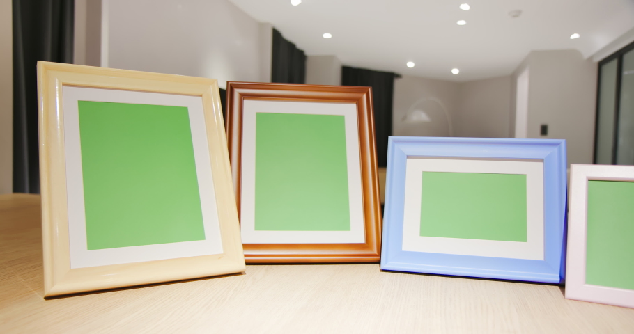 close up of photo frames with green copy space on table in living room at home Royalty-Free Stock Footage #1061153377