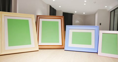 close up of photo frames with green copy space on table in living room at home