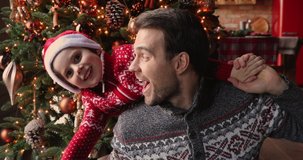 Close up little son wear santa hat lean on dad back family look at camera enjoy video call talk with family, spend time near bright decorated Christmas tree, videocall event, winter holidays concept