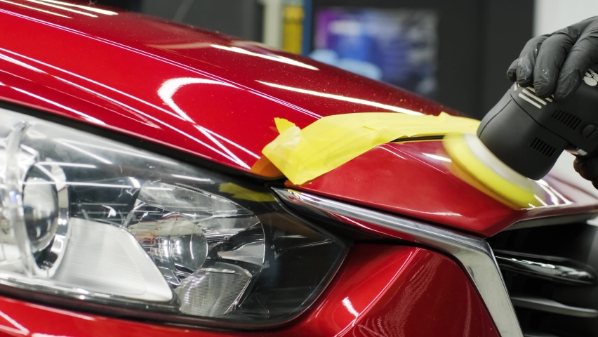 Worker polish a red car. Car detailing - Men are using machinery car polishers maintenance to remove marks repair according to the surface of the car's paint before contin | Shutterstock HD Video #1061163682