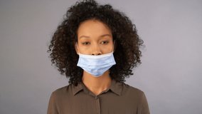young mixed race woman wearing incorrectly worn medical mask. Comic video. 4K