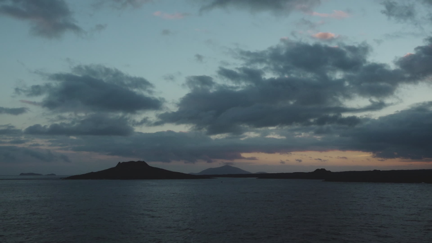 Sunset over the Ocean with Blue Clouds and Glowing Orange Horizon near Chinese Hat Island, Galapagos