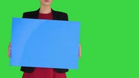 Businesswoman holding blank whiteboard sign on a Green Screen, Chroma Key. - Powered by Shutterstock - Get 15% off with code: PIKWIZARD15
