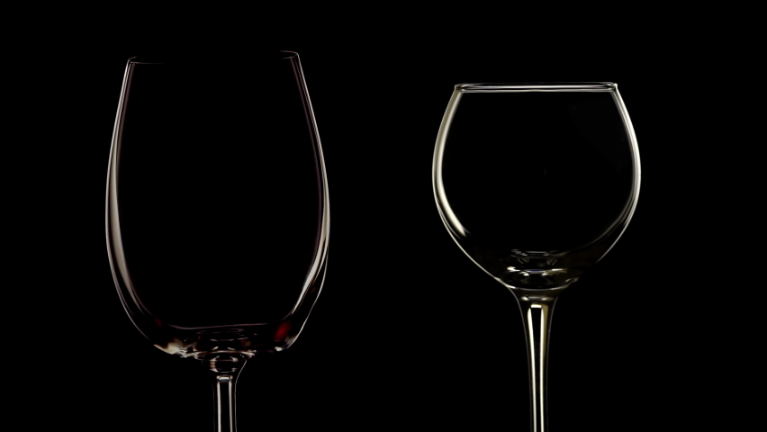 Slow motion red and white wine pour into wine glass. Black isolated background, low key | Shutterstock HD Video #1061177401